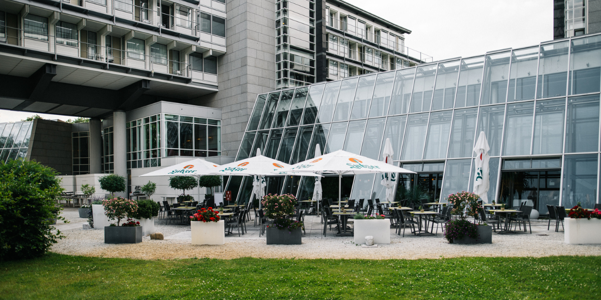 Restaurantterrasse, Sonnenschirme, Tische mit Stühlen, Blumen